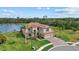 Stunning lakefront property featuring lush landscaping and a beautiful tile roof at 20831 Valprato Ct, Venice, FL 34293