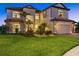 Exterior elevation of a two-story home featuring a well-manicured lawn, a two car garage, and a tile roof at 20831 Valprato Ct, Venice, FL 34293