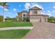 Stately two-story home featuring a three-car garage, tile roof and paved driveway with lush landscaping at 20831 Valprato Ct, Venice, FL 34293