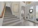 Inviting foyer with grand staircase, decorative glass front door, and neutral tile flooring at 20831 Valprato Ct, Venice, FL 34293