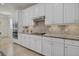 Bright kitchen featuring white cabinets, granite countertops, stainless steel appliances, and stylish backsplash at 20831 Valprato Ct, Venice, FL 34293