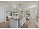 Open kitchen with a large island, pendant lighting, stainless steel appliances, and adjacent dining area at 20831 Valprato Ct, Venice, FL 34293