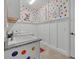 Charming laundry room with colorful polka dots, custom cabinets, and a utility sink at 20831 Valprato Ct, Venice, FL 34293