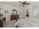 Comfortable main bedroom with detailed ceiling fan, furnishings, and a view to the ensuite bathroom at 20831 Valprato Ct, Venice, FL 34293