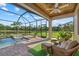 Screened in patio features a pool, lake view, outdoor seating, and tropical landscaping at 20831 Valprato Ct, Venice, FL 34293