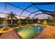 Beautiful backyard with a screened pool, spa, and a tranquil view of the lake at 20831 Valprato Ct, Venice, FL 34293
