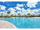 Large community pool featuring plenty of lounge chairs, clear skies and lush landscaping at 20831 Valprato Ct, Venice, FL 34293