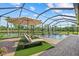 Relaxing screened-in pool area with comfortable lounge chairs and an umbrella with a beautiful lake view at 20831 Valprato Ct, Venice, FL 34293