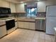 Well-maintained kitchen with appliances, tile flooring, and a window above the sink at 2181 Pine Gardens Trl, Sarasota, FL 34231