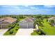 Aerial view showcasing the well-maintained home with lush lawn and tropical landscaping at 2240 Crystal Lake Trl, Bradenton, FL 34211