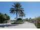 Community entrance gate with a palm tree, landscaping, and security features at 2240 Crystal Lake Trl, Bradenton, FL 34211