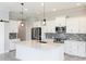 Modern kitchen featuring white cabinets, stone countertops, mosaic backsplash, and stainless steel appliances at 2240 Crystal Lake Trl, Bradenton, FL 34211