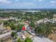 Aerial view of the house with mature trees and an industrial park in the distance at 2411 5Th Avenue E Dr, Palmetto, FL 34221