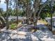 Charming home featuring stucco exterior, dark blue door, decorative pillar accents, and large mature trees at 2411 5Th Avenue E Dr, Palmetto, FL 34221