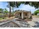 Charming home featuring stucco exterior, dark blue door, decorative pillar accents, and mature trees at 2411 5Th Avenue E Dr, Palmetto, FL 34221