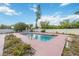 Backyard pool with pink patio and landscaping in a secluded outdoor setting at 2606 Bismark Way, Sarasota, FL 34231
