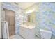 Cozy bathroom featuring whimsical palm tree wallpaper, shower, and single sink vanity at 2606 Bismark Way, Sarasota, FL 34231