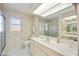 Well-lit bathroom featuring a single sink vanity, patterned wallpaper, and a glass-enclosed shower at 2606 Bismark Way, Sarasota, FL 34231