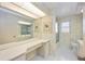 Bright bathroom with shower, toilet, a large mirror, and built in desk at 2606 Bismark Way, Sarasota, FL 34231