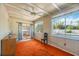 Living room features wood beam ceiling, orange carpet and view to patio with pool at 2606 Bismark Way, Sarasota, FL 34231