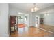 Bright living room featuring wood floors and a mirrored wall with a glimpse into a sunroom at 2606 Bismark Way, Sarasota, FL 34231