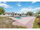Backyard pool with pink deck and mature landscaping, adjacent to house and patio at 2606 Bismark Way, Sarasota, FL 34231