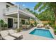 Spacious backyard featuring a pool, outdoor kitchen, dining area, and lounge, perfect for entertaining at 2655 Bay St, Sarasota, FL 34237