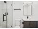 Modern bathroom with frameless shower, black hardware, and white vanity at 2655 Bay St, Sarasota, FL 34237
