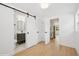 Hallway features barn door to bathroom, opens to kitchen, and has hardwood floors at 2655 Bay St, Sarasota, FL 34237