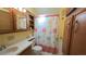 Bathroom featuring a colorful shower curtain, vanity, and storage shelves at 3333 26Th E Ave # 1132, Bradenton, FL 34208