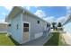 Light blue home exterior featuring concrete walkway, stairs, and well-maintained lawn at 3333 26Th E Ave # 1132, Bradenton, FL 34208