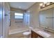 Bright bathroom featuring a bathtub with shower, tiled walls, and a granite-topped vanity with modern fixtures at 4102 Lakewood Ave, Bradenton, FL 34208