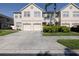 View of townhome featuring a two-car garage, well-maintained lawn, and mature landscaping at 4103 Foristall Ave # 4103, Sarasota, FL 34233