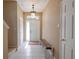 Inviting foyer with tiled flooring, bench seating, and a decorative light fixture at 4103 Foristall Ave # 4103, Sarasota, FL 34233