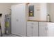 Neat utility room featuring water heater, electrical panel, and storage cabinets at 4103 Foristall Ave # 4103, Sarasota, FL 34233