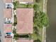 Aerial view of the terracotta roofed building showing assigned parking and a pond at 4254 Vicenza Dr # B, Venice, FL 34293