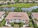 Aerial view of condo building with a terracotta roof next to a pond with green surroundings at 4254 Vicenza Dr # B, Venice, FL 34293