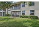 A sunny day view of the condo's exterior featuring a screened patio and well-maintained lawn at 4254 Vicenza Dr # B, Venice, FL 34293