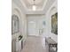 Elegant foyer with tile flooring, arched doorways, mirrored decor, and chic furniture at 4254 Vicenza Dr # B, Venice, FL 34293