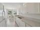 Bright kitchen with white cabinets, tiled floors, and dining area with window view at 4254 Vicenza Dr # B, Venice, FL 34293