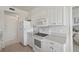 Bright kitchen features white appliances, cabinets, and a view into a bedroom at 4254 Vicenza Dr # B, Venice, FL 34293