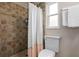 Clean bathroom with tiled shower, white toilet, and a bright window offering natural light at 4405 Linwood St, Sarasota, FL 34232