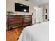 Bedroom featuring wood floors, a wooden dresser with TV, and an open doorway to the bathroom at 4405 Linwood St, Sarasota, FL 34232