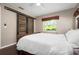 Bright bedroom features a sliding barn door closet and a large window overlooking the outdoor landscape at 4405 Linwood St, Sarasota, FL 34232