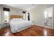 Bright bedroom with hardwood floors, a woven headboard, and a view of the outdoors through the windows at 4405 Linwood St, Sarasota, FL 34232