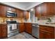 Kitchen featuring stainless steel appliances, wood cabinets, and tile backsplash at 4405 Linwood St, Sarasota, FL 34232