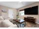 Cozy living room with tile floors, neutral colors and modern entertainment center at 4405 Linwood St, Sarasota, FL 34232