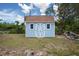 Pastel blue shed with white trim and a brown roof, in a yard with greenery at 4405 Linwood St, Sarasota, FL 34232