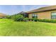 Spacious backyard with green grass, manicured hedges, and a view of the screened-in patio at 4416 Amalfi Ave, Sarasota, FL 34243
