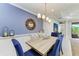 Elegant dining room with stylish lighting, blue accent wall, and outdoor view at 4416 Amalfi Ave, Sarasota, FL 34243